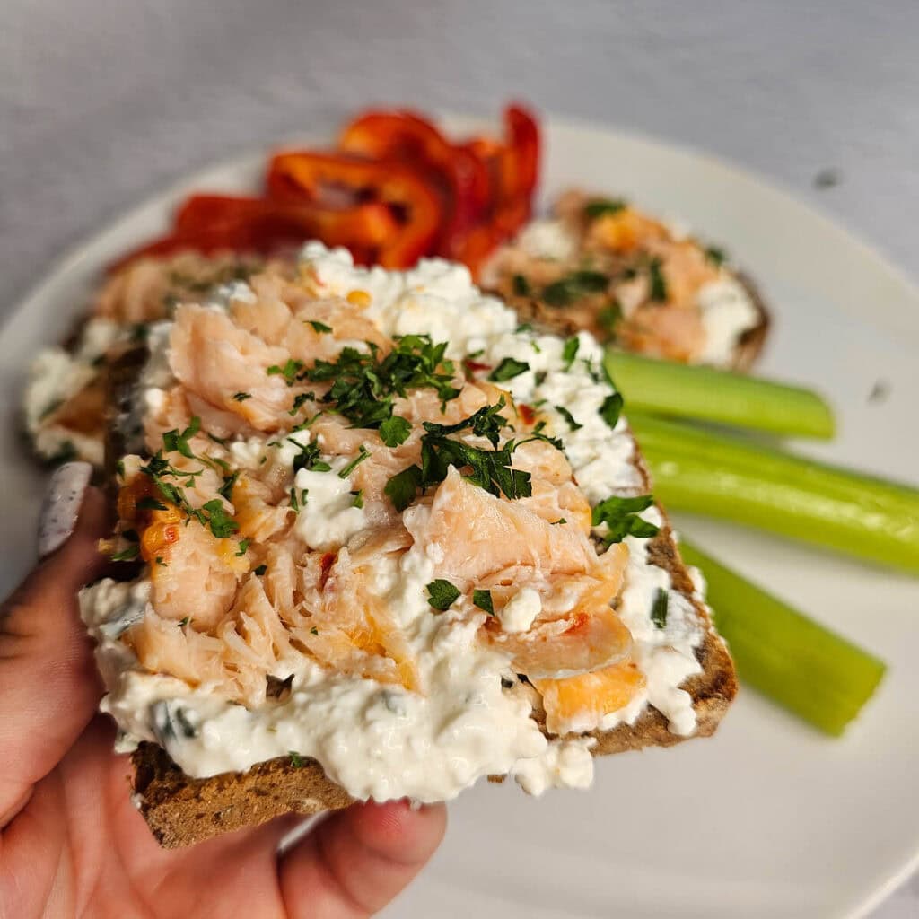 Świeży tosty z łososiem, twarogiem i świeżą zieleniną, podane z selerem naciowym – pyszny wybór na relaksujący posiłek.