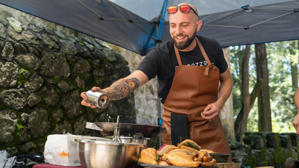 Kucharz w plenerze, grillowanie na świeżym powietrzu, naturalne otoczenie, las i kamienne mury, atmosfera relaksu i rekreacji na stronie relaxwterenie.pl.